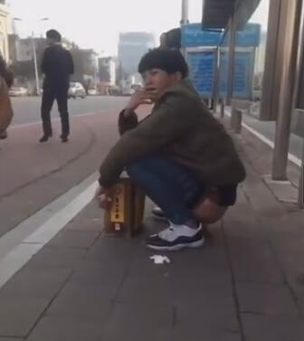 实拍﹕小伙公交站叼烟大便﹗身旁姑娘左顾右盼